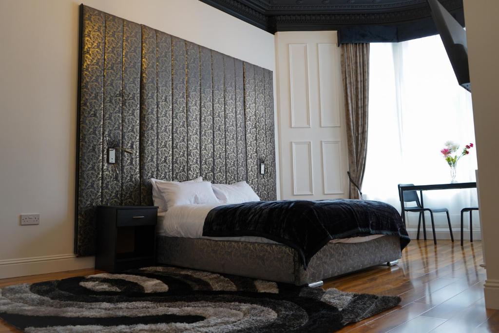 格拉斯哥S.H Apartments的一间卧室配有一张黑色墙壁的床