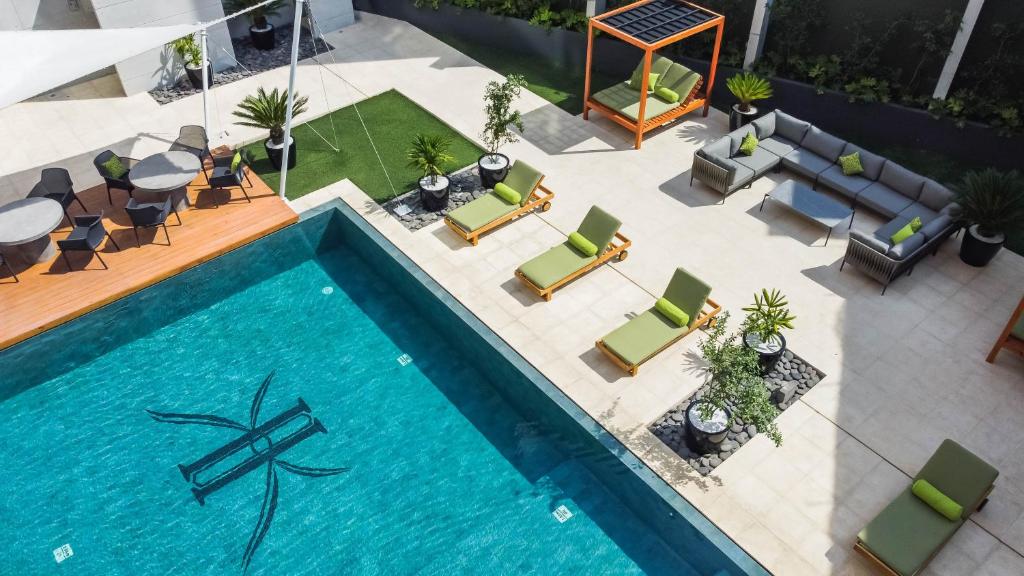 危地马拉Adriatika Hotel & Residence的享有带桌椅的游泳池的顶部景致