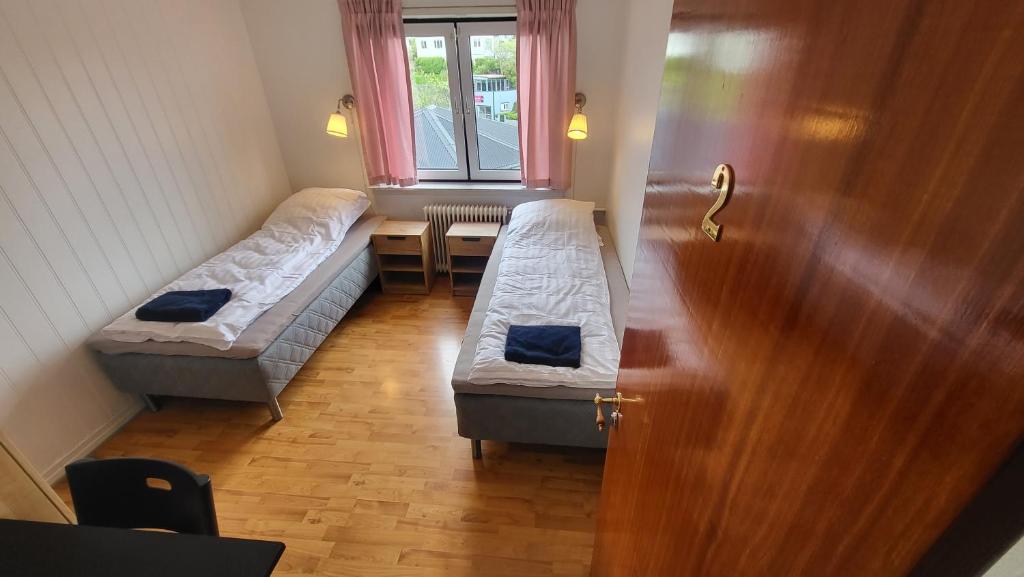 托尔斯港Heart of the City (Hotel Bólið Guesthouse)的客房设有两张床和一张带窗户的桌子。