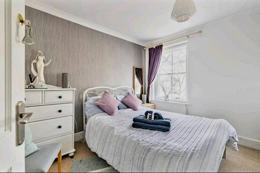 卡迪夫The Mews的卧室配有白色床和紫色枕头