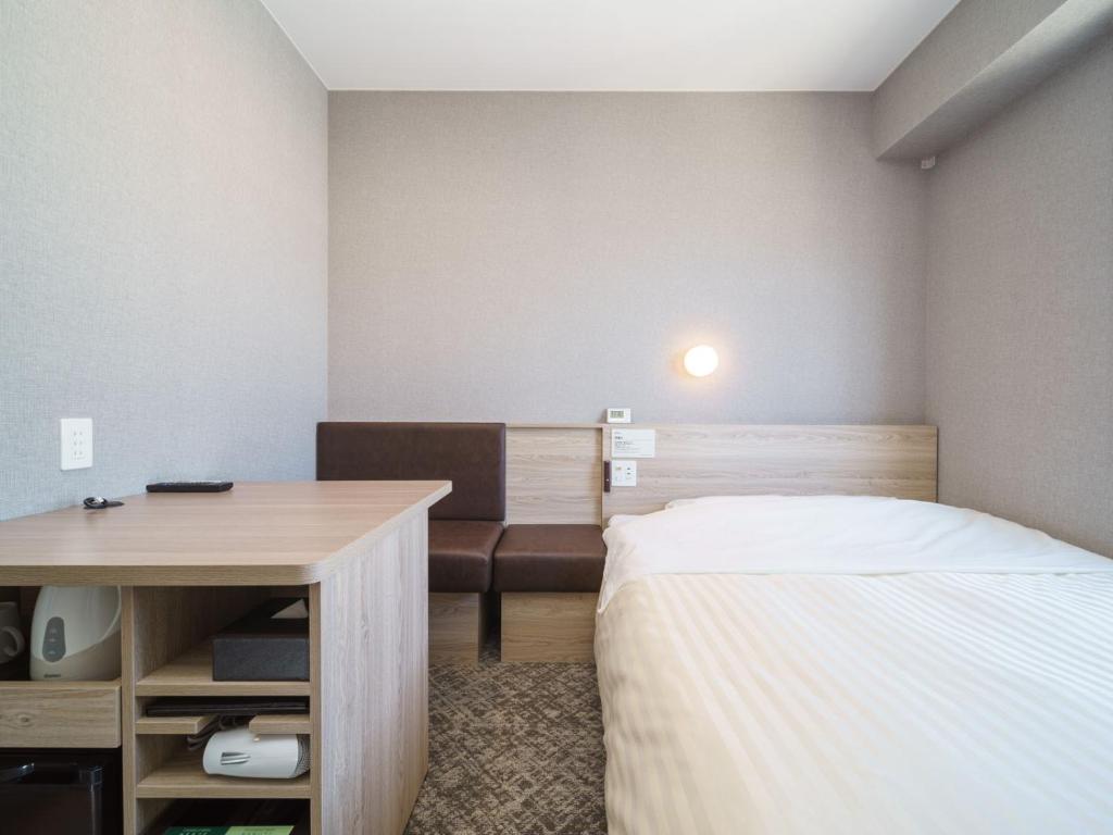 藤泽Super Hotel Shonan Fujisawaeki Minamiguchi的小房间设有一张床和一张书桌