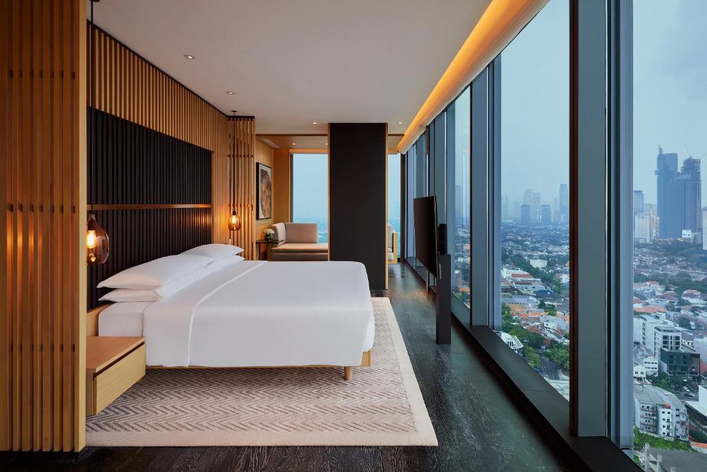 雅加达Park Hyatt Jakarta的卧室设有白色的床和大窗户