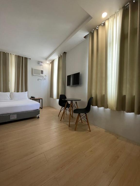 公主港Bambu Suites的卧室配有一张床和一张桌子及椅子