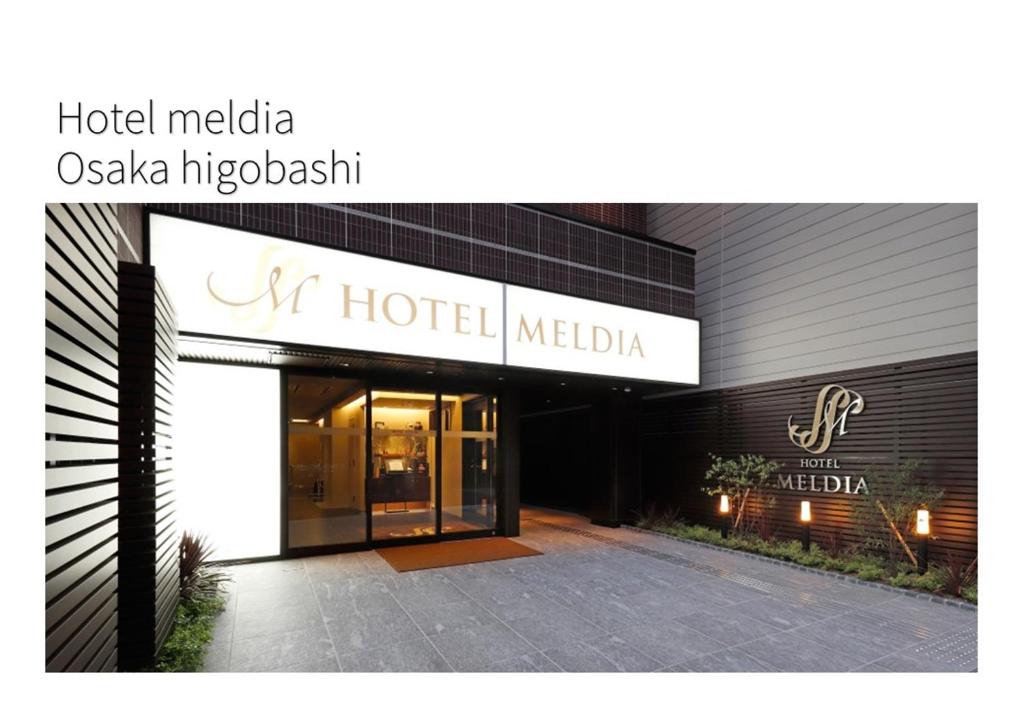大阪Hotel Meldia Osaka Higobashi的大楼前的美丽亚绿洲岛标志