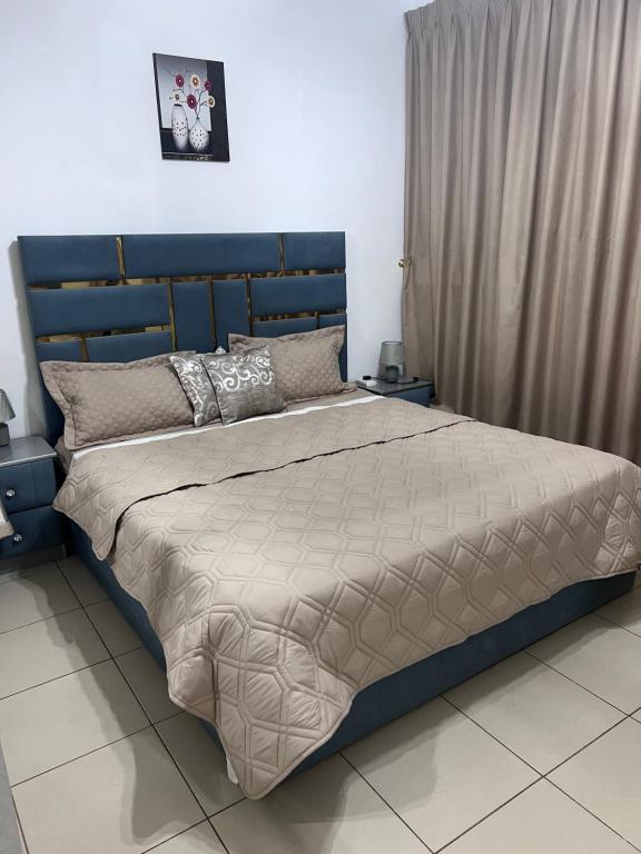 阿吉曼Reem 1的卧室里一张带蓝色床头板的床