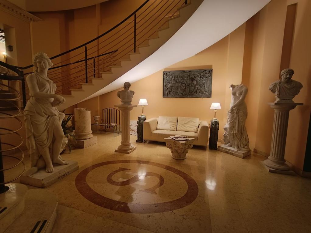 菲乌米奇诺Seccy Hotel Boutique Art & Museum的一间带雕像和楼梯的客厅