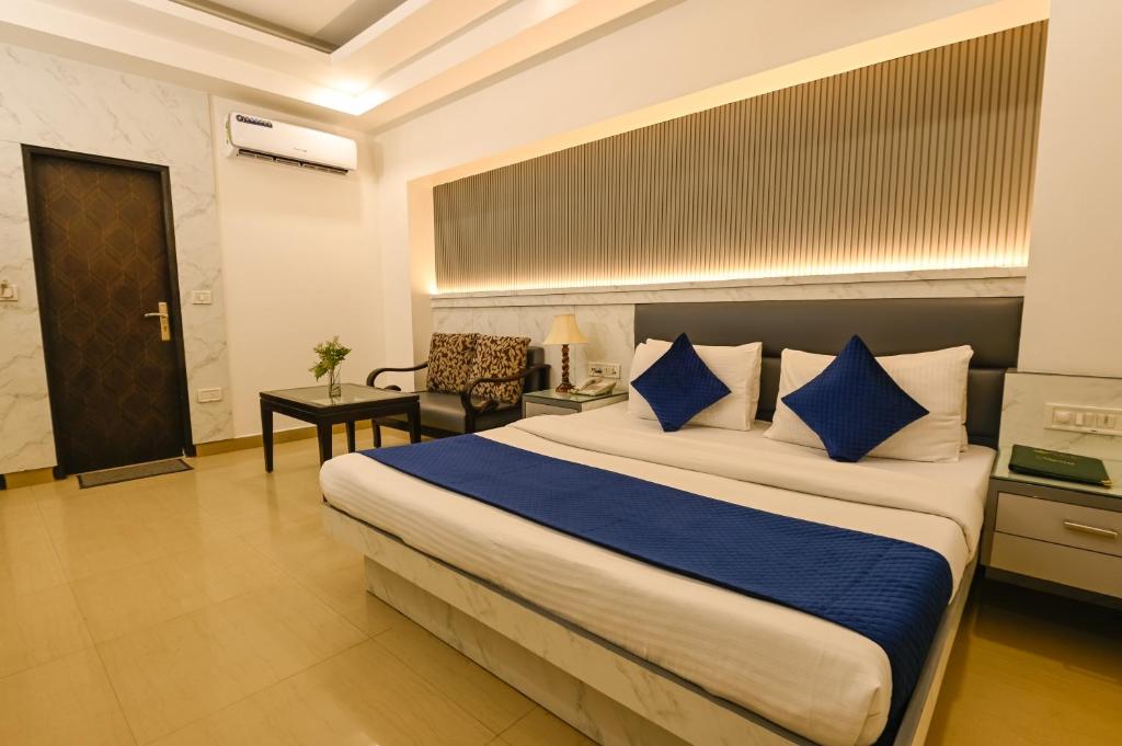 新德里Hotel Krishna Deluxe-By RCG Hotels的一间卧室配有一张带蓝色枕头的大床