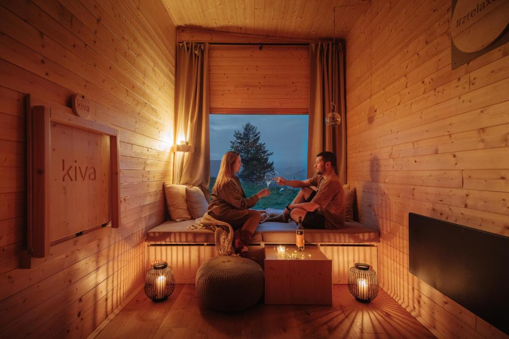 Horné Hámrekiva cabin的两人坐在一个窗户房间里沙发上