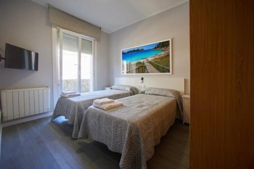维戈Calvario 4的一间卧室配有两张床和电视。