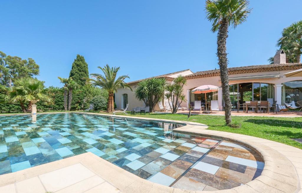 圣特罗佩Villa Alizée B&B的棕榈树屋前的游泳池