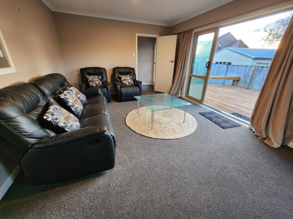 汉密尔顿Endeavour Adventures的客厅配有真皮沙发和玻璃桌