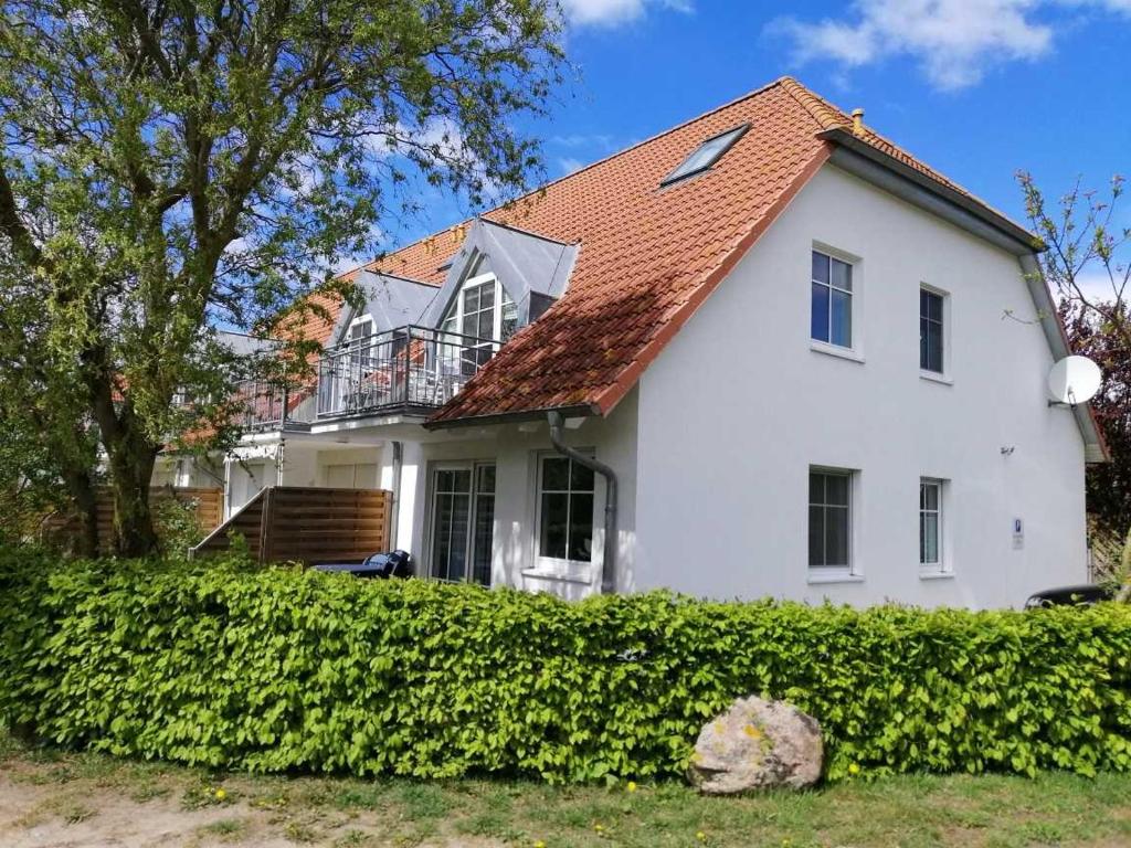 蒂门多夫Ferienwohnung Sonneneck Poel的白色房子,有红色屋顶