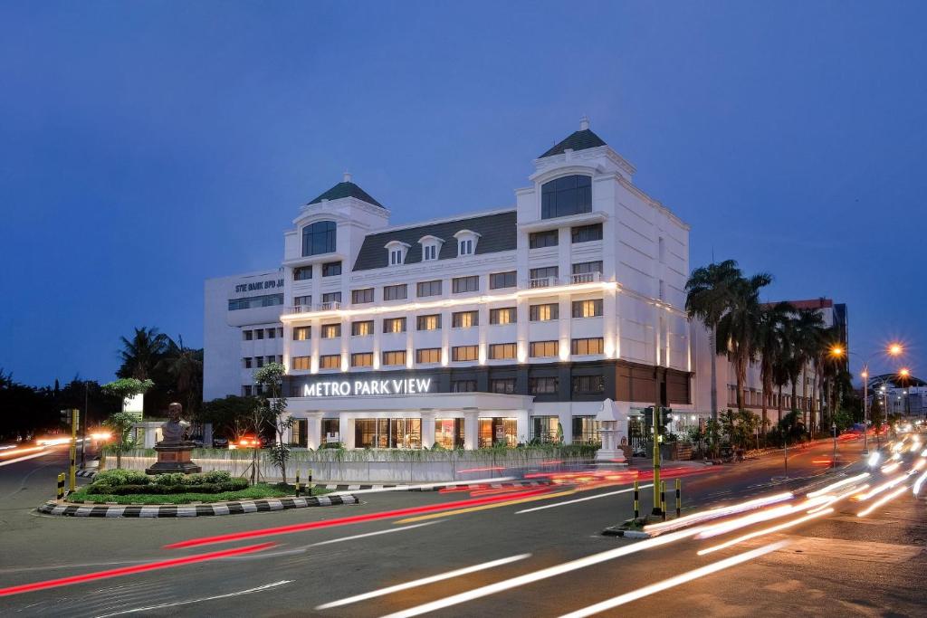 三宝垄Metro Park View Hotel Kota Lama Semarang的夜行的街道上一座白色的大建筑