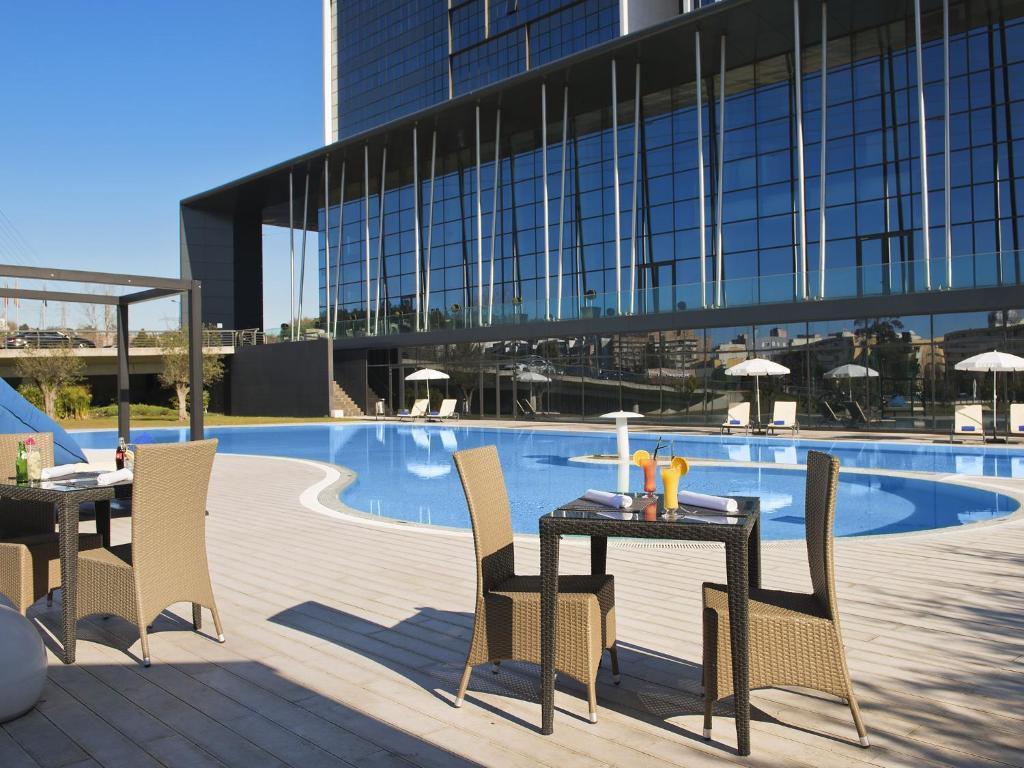 布拉加布拉加美利亚Spa酒店的游泳池旁的桌椅
