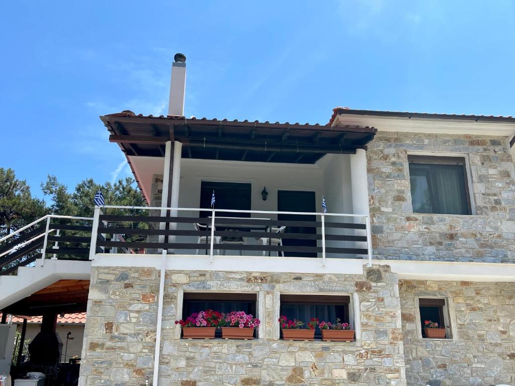 基尼拉Miro & Lana vacation home的一座建筑,设有两个阳台,窗户上装有鲜花