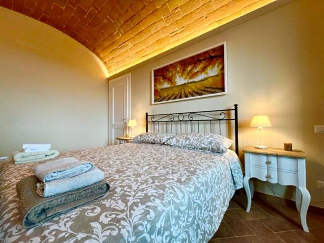 波吉邦西Sangi Chianti Vacations的一间卧室配有带2个床头柜和一幅画的卧室