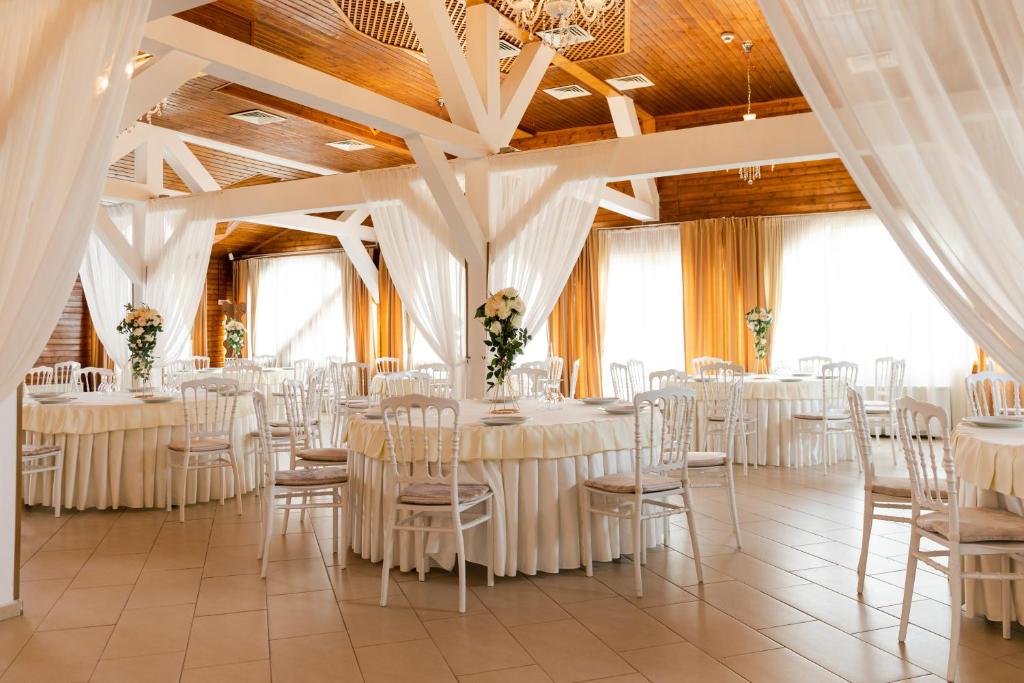 Sîncraiu de MureşComplex Turistic Darina Sancraiu de Mures的宴会厅配有白色的桌椅