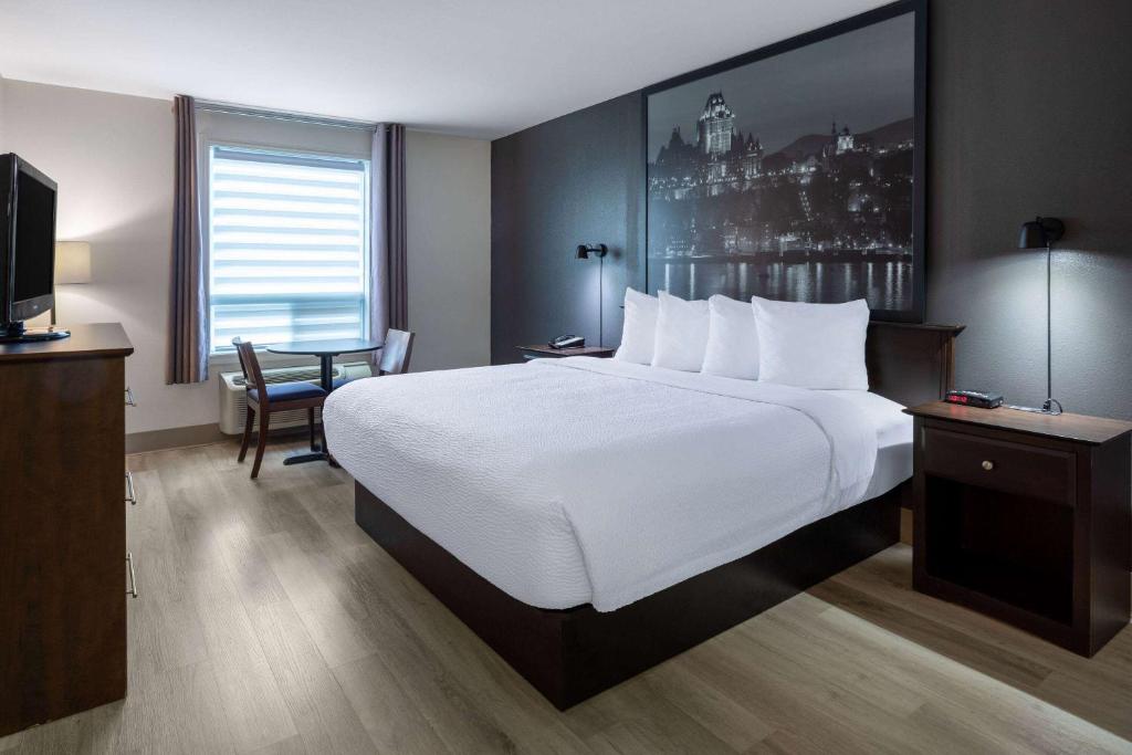 魁北克市速8魁北克斯蒂富酒店的酒店客房设有一张大床和一台电视。