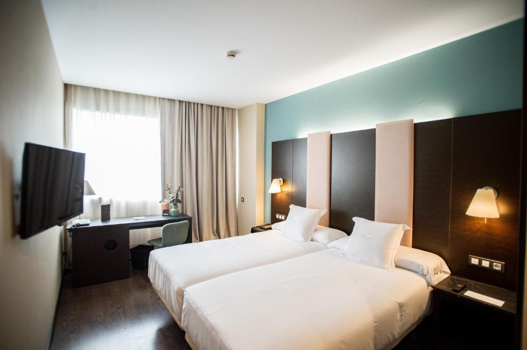 潘普洛纳AZZ Pamplona Norte Hotel的酒店客房设有一张大床和一台电视。
