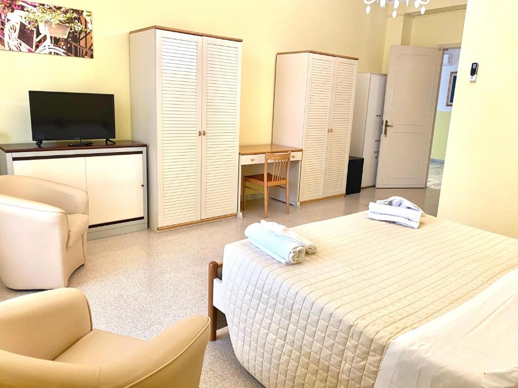 莱切OSTELLO MADRE SANTINA的一间卧室配有一张床、一把椅子和电视