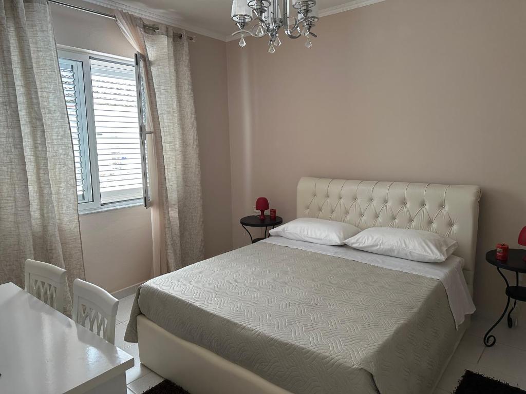 培拉特Andrea House的白色卧室配有一张床和一个吊灯