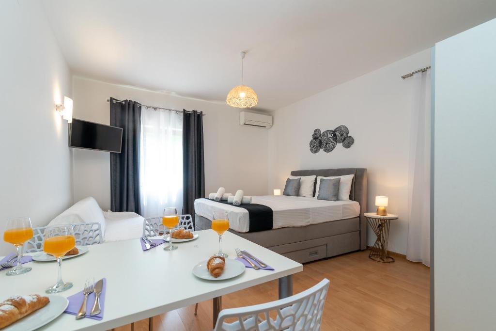 特罗吉尔Apartments Bozan的配有一张床和一张桌子及两把椅子的房间