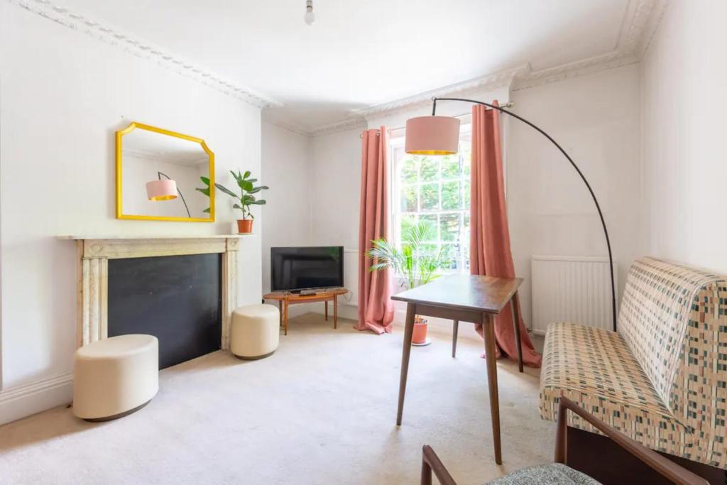 伦敦Charming & Central 2BD Flat - Islington的客厅配有桌子和壁炉