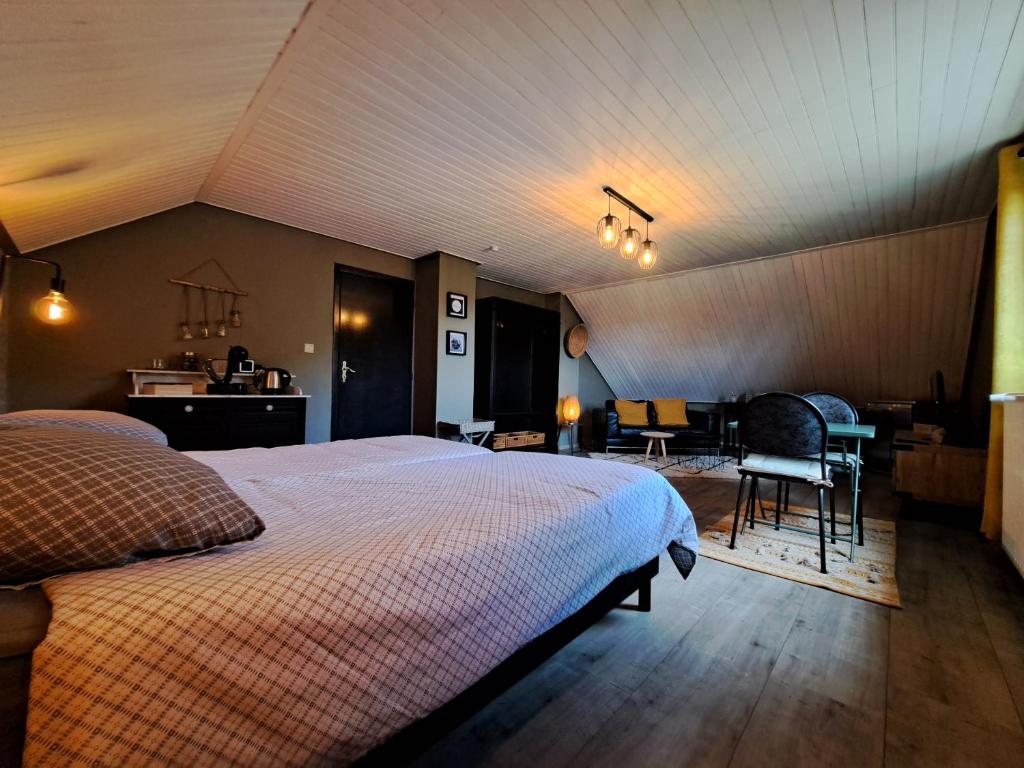 威布林Chez Baf - Wibrin - Houffalize的卧室配有一张床和一张桌子及椅子