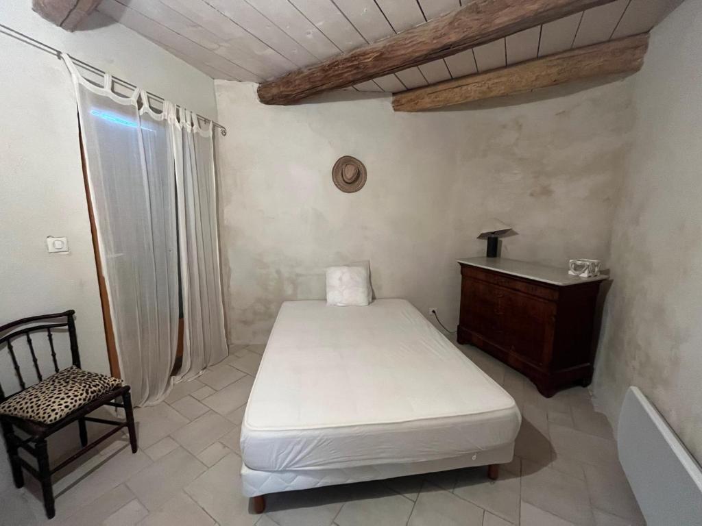 里耶Charming home in Provence - 6 pers.的一间卧室配有一张床、一张桌子和一把椅子