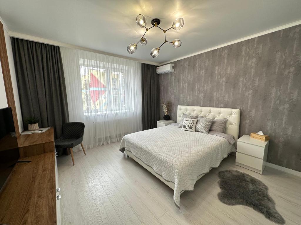 文尼察Comfort Apartment的卧室配有白色的床和吊灯。