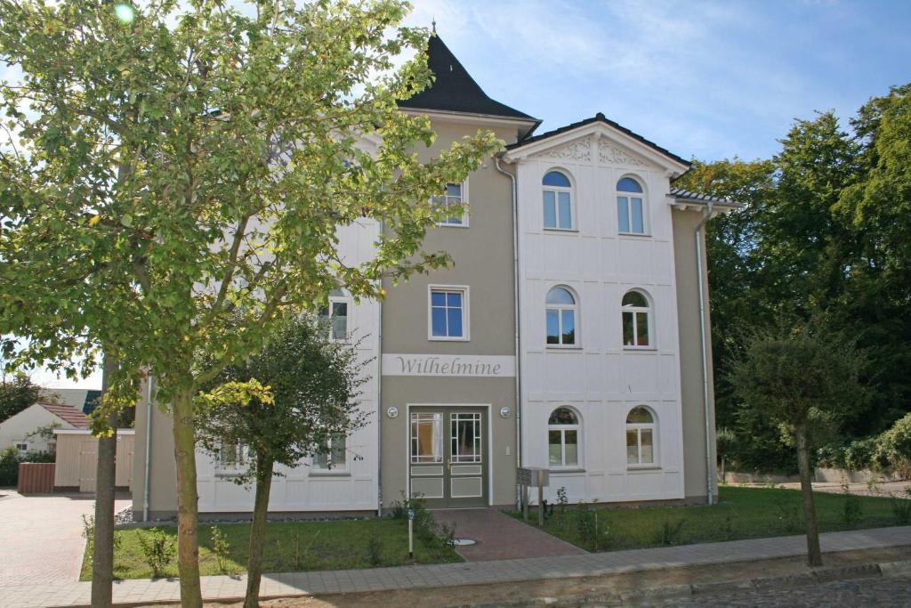 奥斯赛拜-塞林Villa Wilhelmine - FeWo 02 Wilhelm的前面有一棵树的白色大建筑