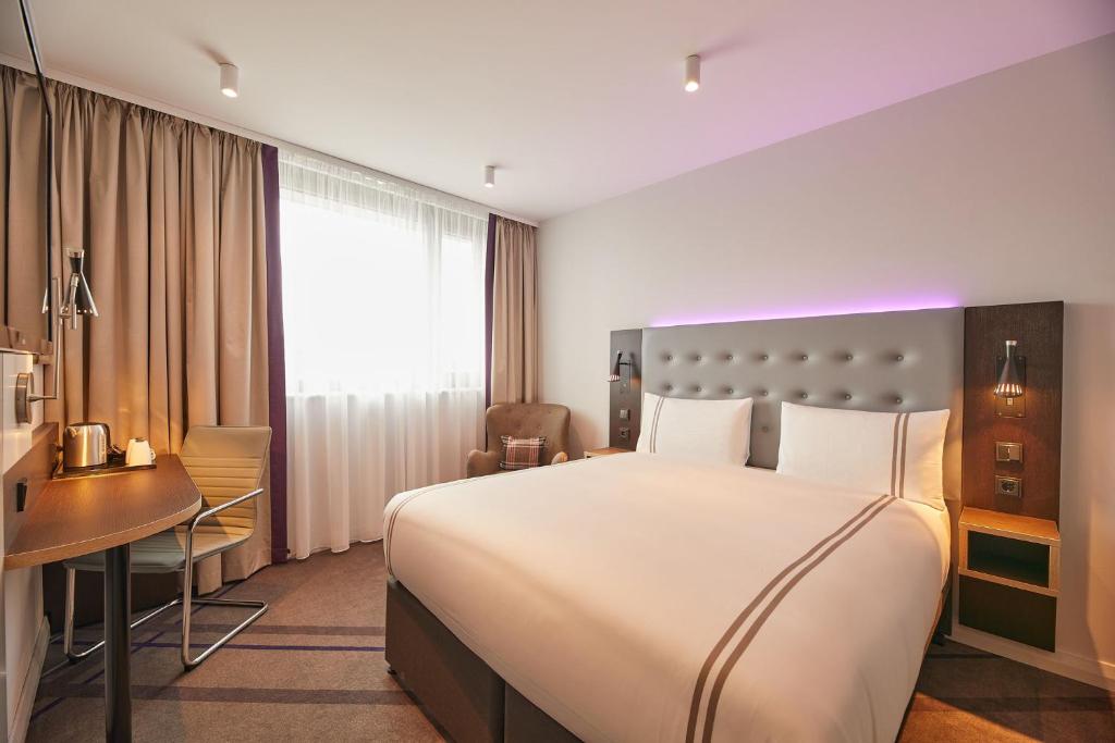 卡尔斯鲁厄Premier Inn Karlsruhe City Am Wasserturm的酒店客房设有一张大床和一张书桌。