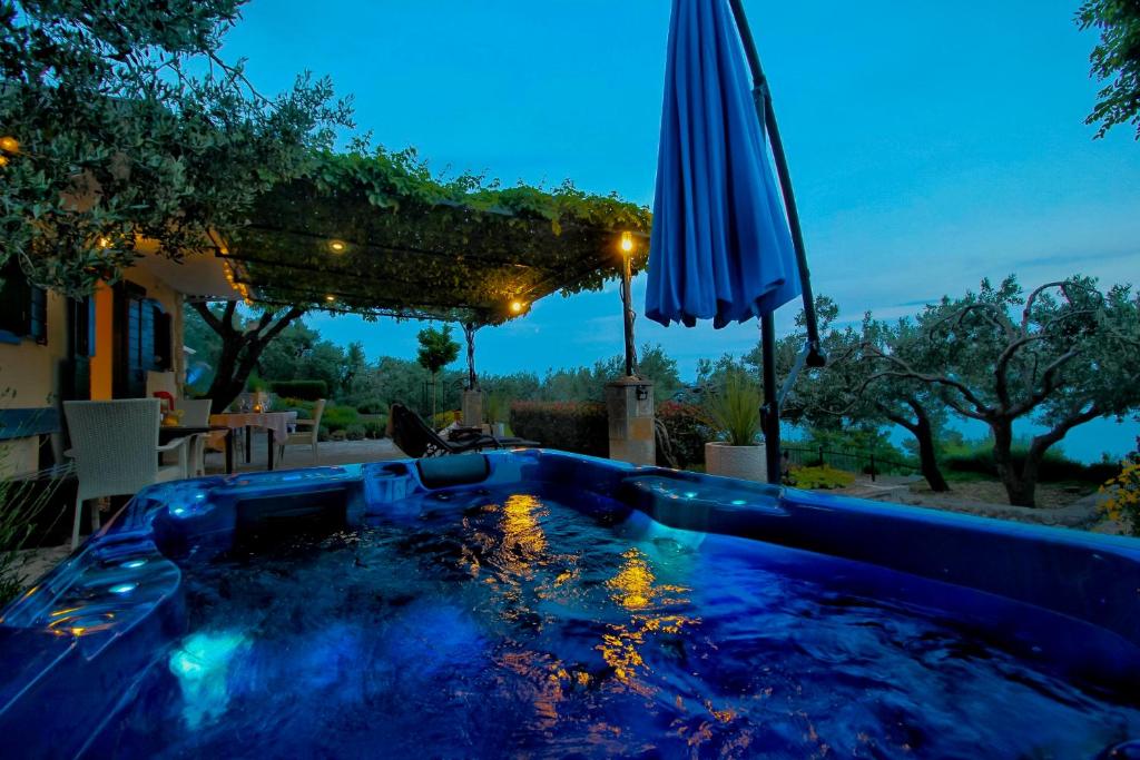 巴什卡沃达Holiday home Oaza的后院的带遮阳伞的游泳池