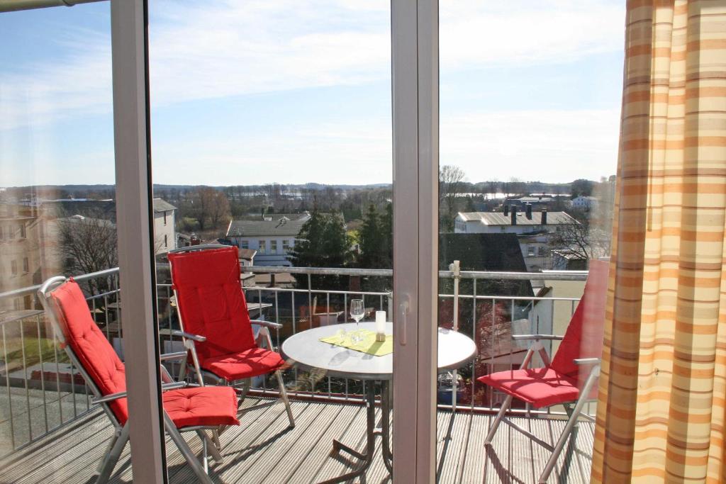奥斯赛拜-塞林Haus Möwe II - Ferienwohnung 10的阳台配有红色椅子和桌子,享有美景。