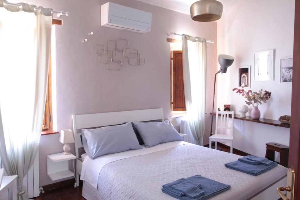马切拉塔CIRIBACCO ROOMS的卧室配有白色床和蓝色毛巾
