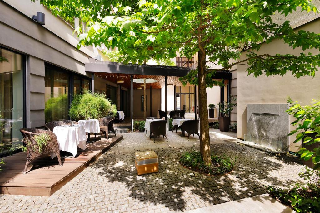 布拉格布拉格三皇冠酒店的一间设有桌椅和树的餐厅