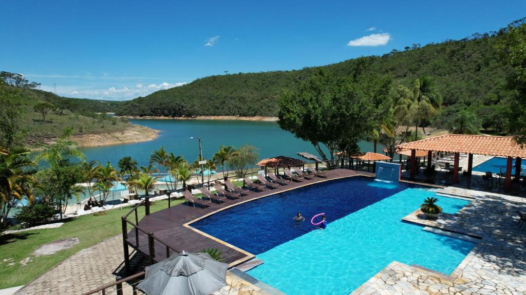 卡皮托利乌Pousada do Rio Turvo的一个带椅子和湖泊的大型游泳池