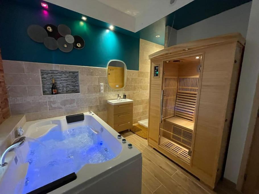 ChartrettesSuite d'amour et détente jacuzzi, sauna et massage的大型浴室设有浴缸和淋浴。