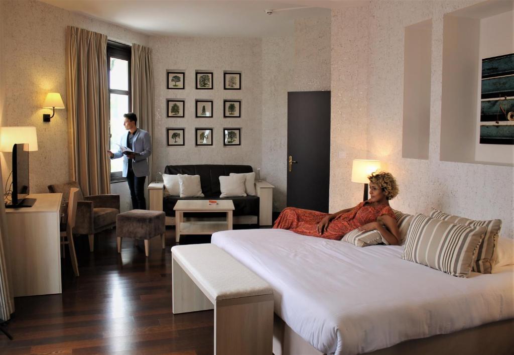 拉罗什波赛Logis Les Loges du Parc的躺在旅馆房间床上的女人