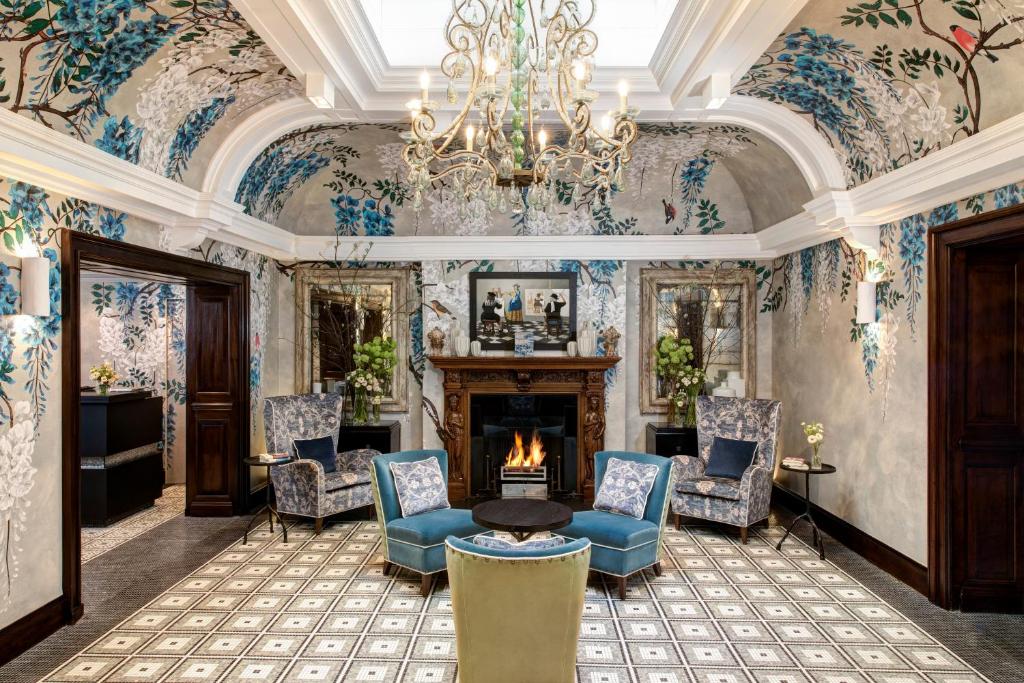伦敦Brown's Hotel, a Rocco Forte Hotel的客厅设有壁炉和花卉壁纸