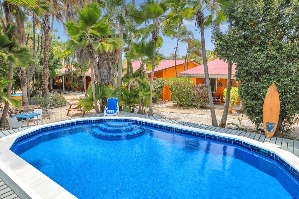 克拉伦代克Tropical Divers Resort的棕榈树屋前的游泳池