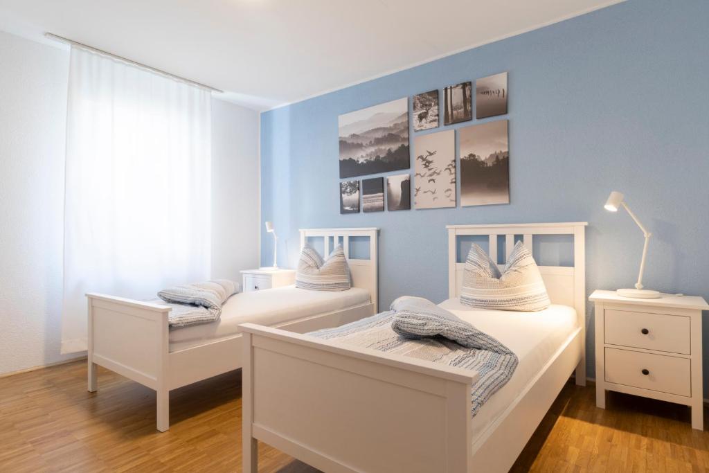 茨魏布肯Haus Oselbach- Gemütlich, Zentral, Modern的蓝色墙壁客房的两张床