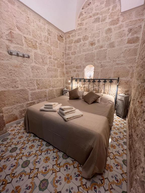 奥斯图尼Casa Mirabilis 44的卧室配有砖墙内的床铺