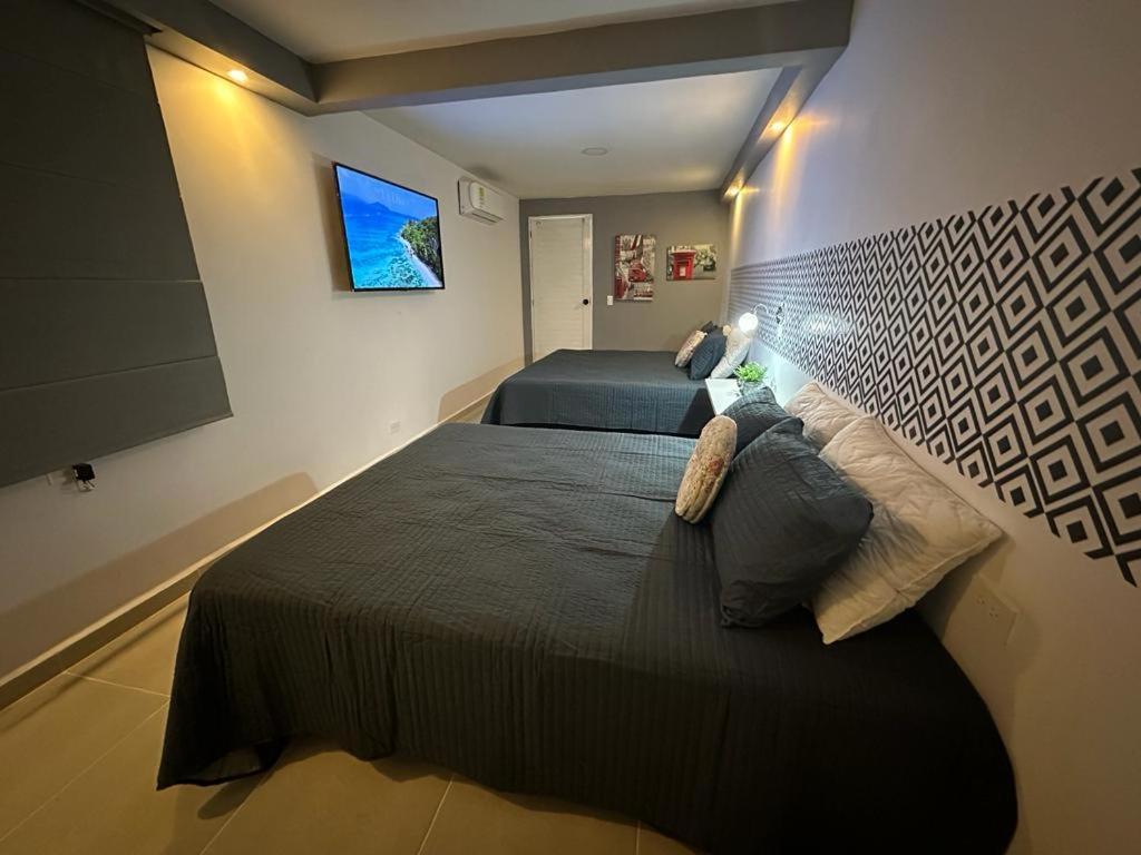 布加CASA10 DIEZ En TODO !的一间卧室设有两张床,墙上配有电视。