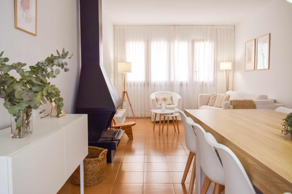 贝萨卢Can Falga Alojamiento en el corazón de Besalú的客厅配有桌子和白色椅子