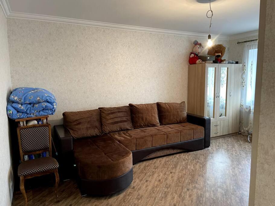 塞凡Aram Guest House的客厅配有棕色沙发和椅子