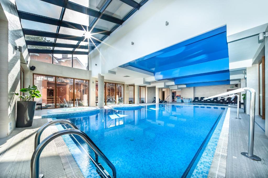 里沃日落Spa酒店的大楼内的大型游泳池,配有大电视