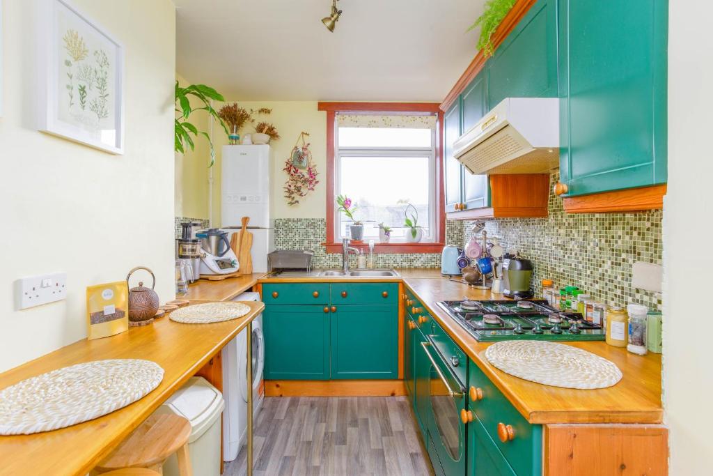 爱丁堡Nordic style room in a quiet residential area的厨房配有蓝色橱柜和台面