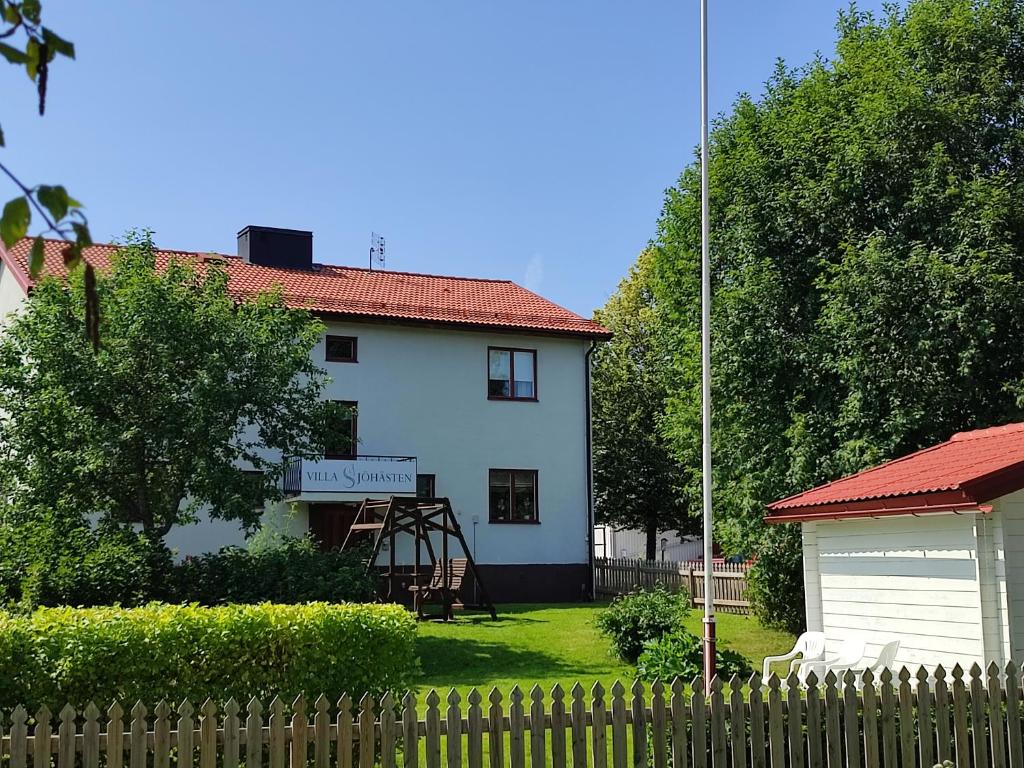 格兰耶德Villa Sjöhästen的前面有栅栏的白色房子