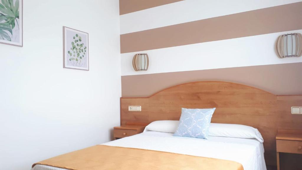 比利亚隆加Habitaciones Ninfa的一间卧室配有一张带木制床头板的床